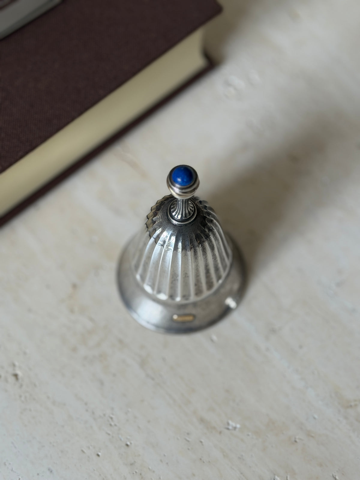 Close-up from above of the fluted handle and lapis cabochon finial, showing the beaded detail around the stone