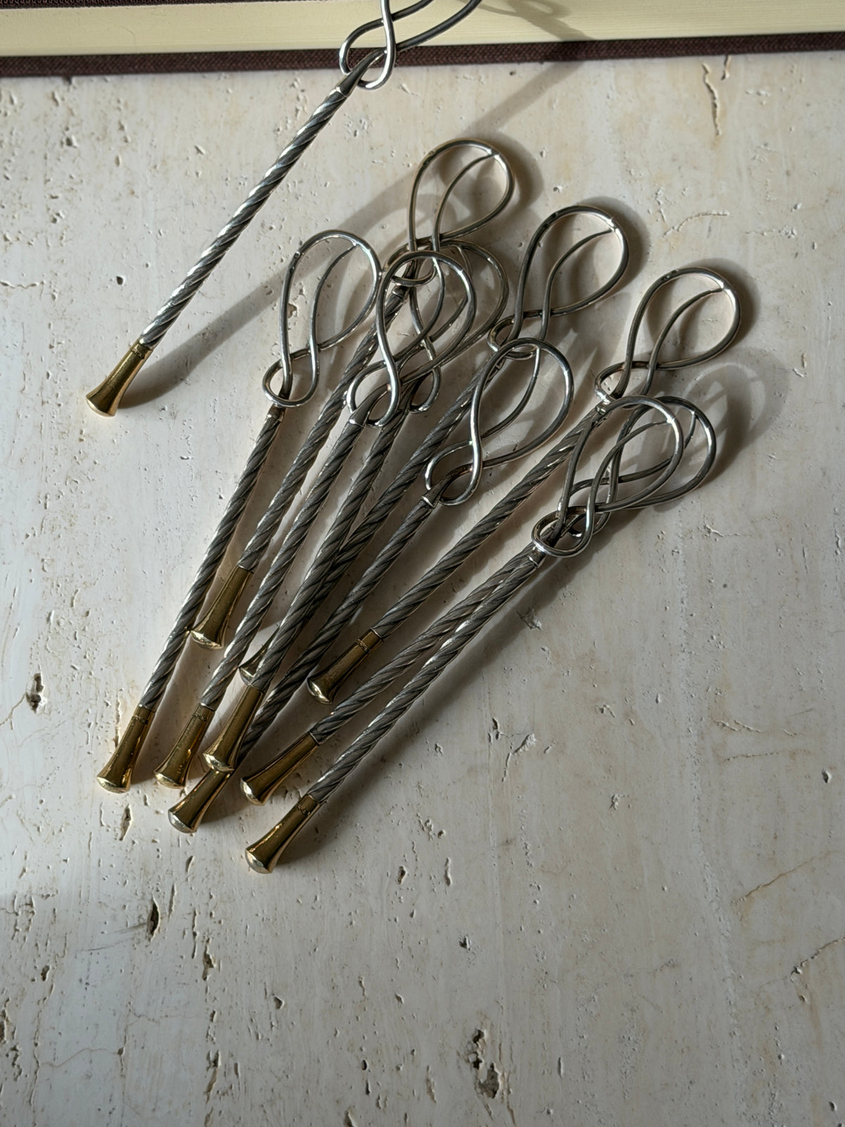 Close view of the Hermes stirrers in sunlight, showing the open figure eight loops and the cable twist running down each stem