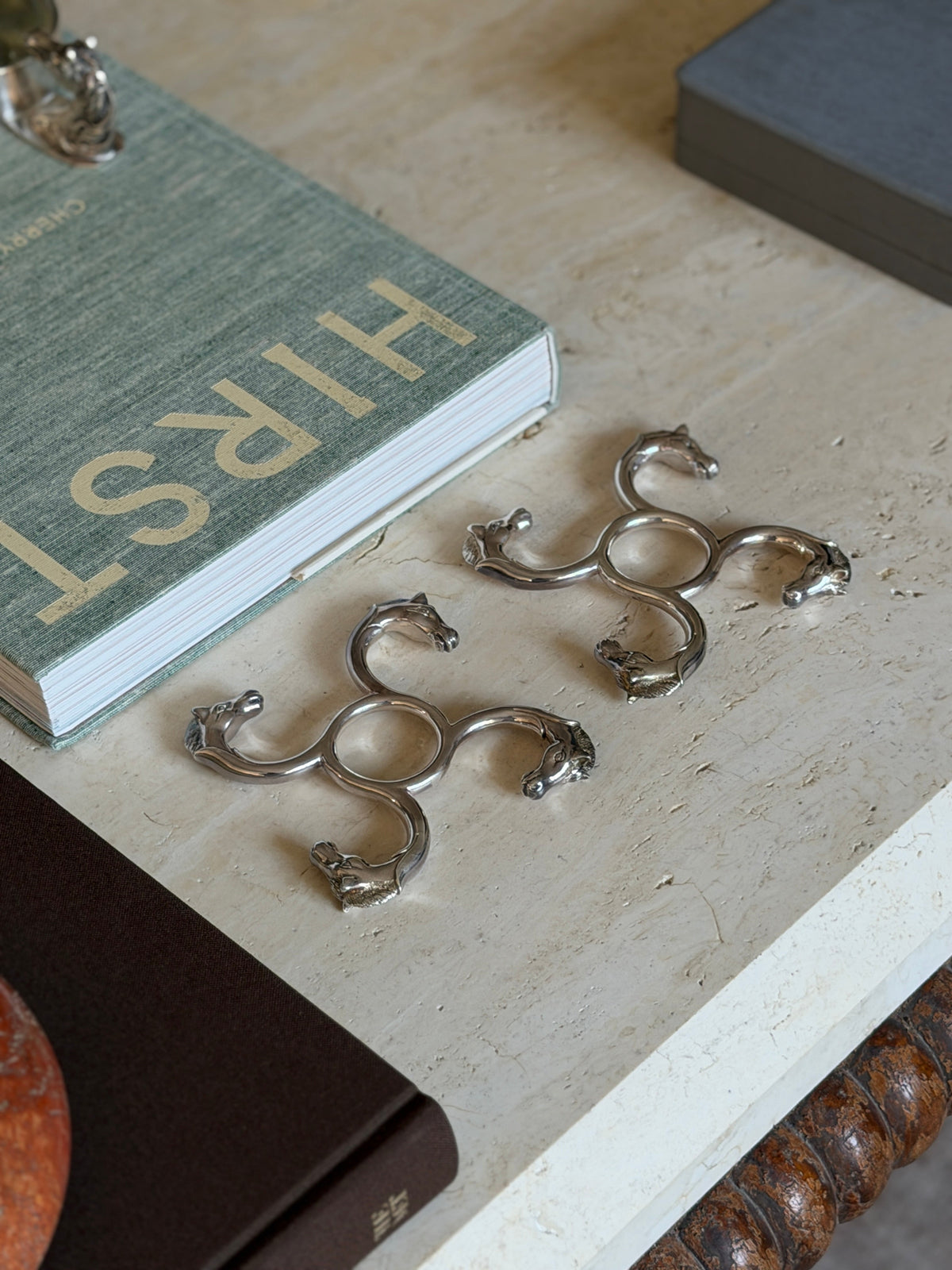 Stylized view of one Hermes horse head coaster showing both coasters