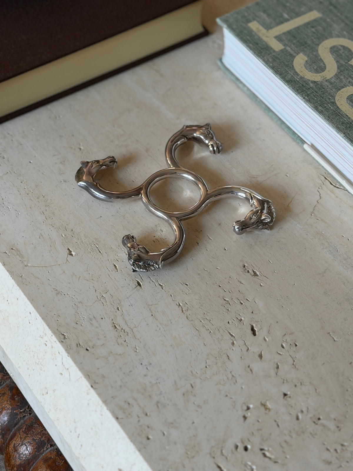 Top-down view of the Hermes silver horse head coaster showing the sculptural detail