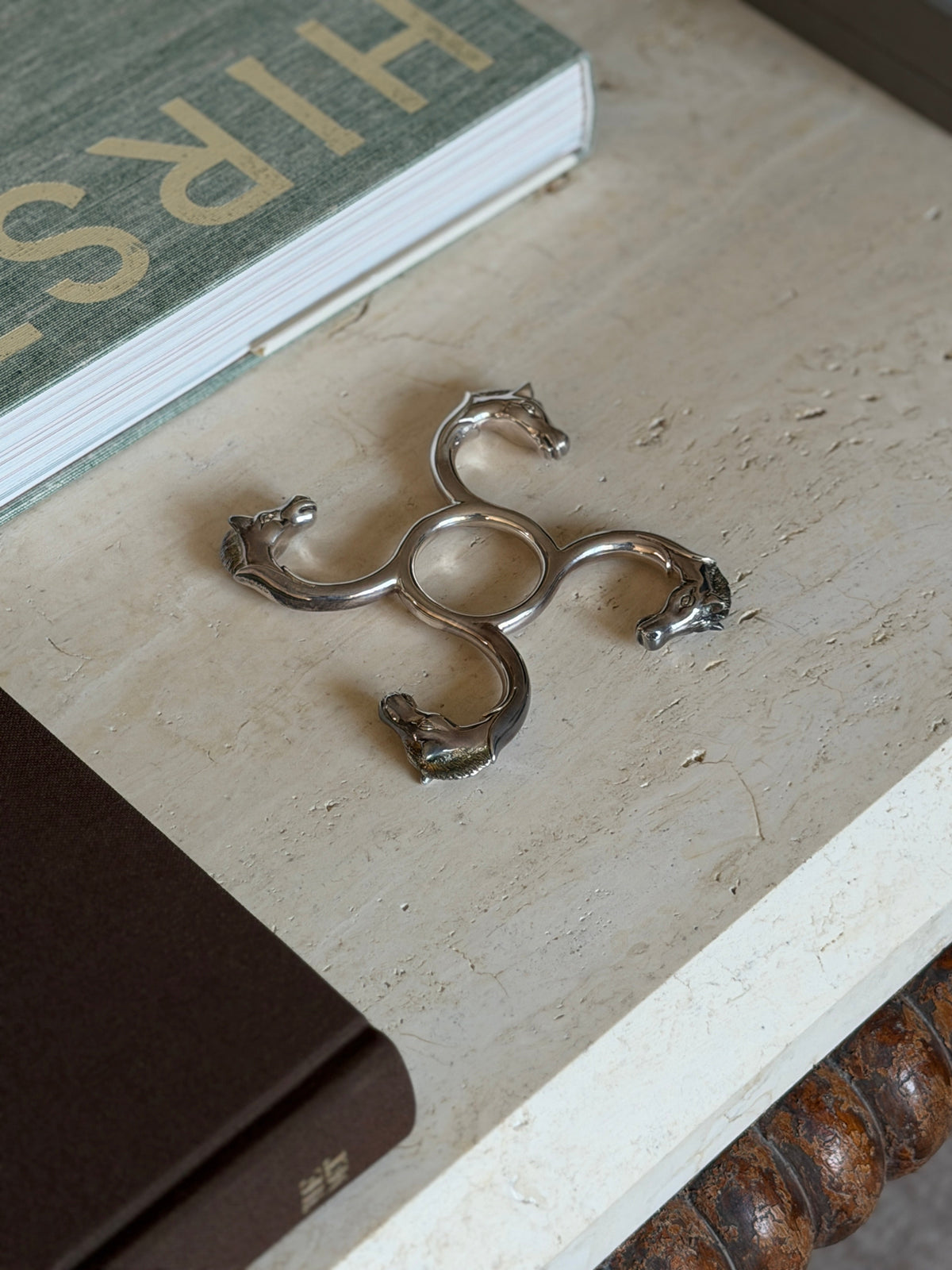 Overhead view of the Hermes horse head coaster styled near stacked books