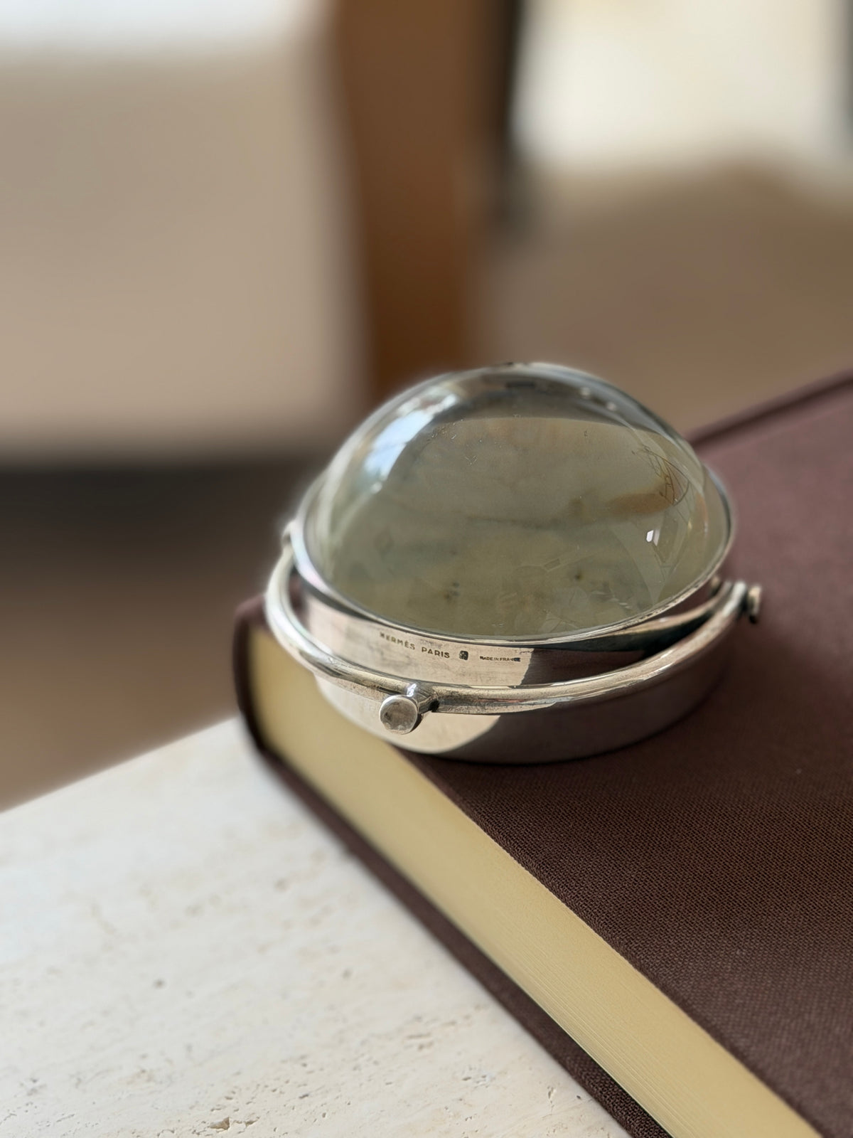 Extreme close-up of the lens rim showing the Hermes Paris and Made in France stamps beside the spur handle