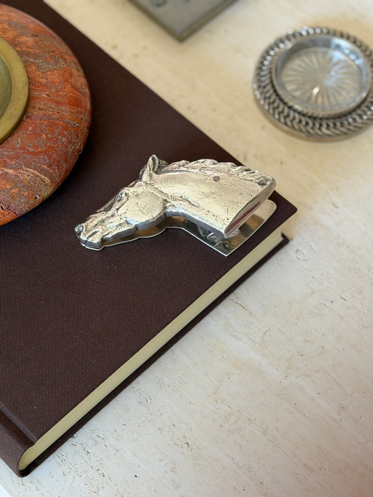 Hermes horse head paper clip clipped onto the corner of a book&