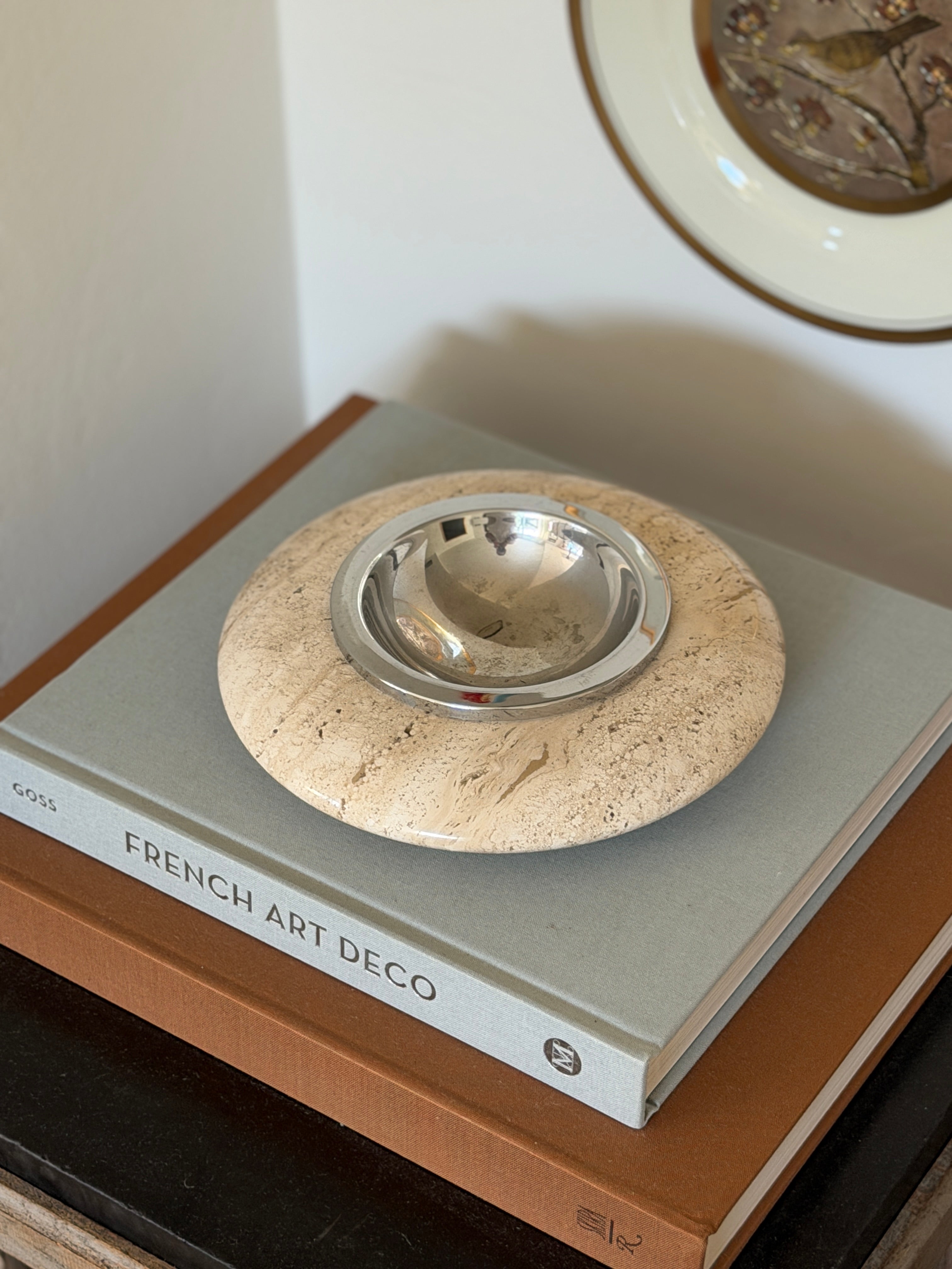 High angle perspective view of round ivory travertine catchall tray displayed on an interior coffee table