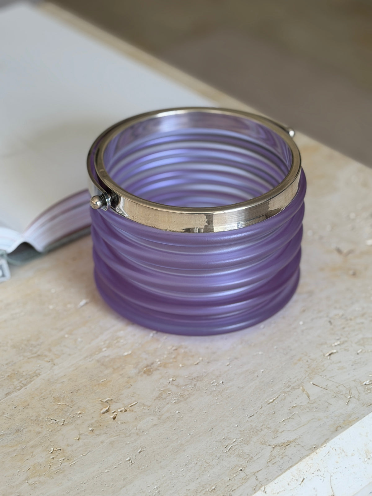 Straight-on view of the bucket showing the full wave-like ribbing along its frosted purple body