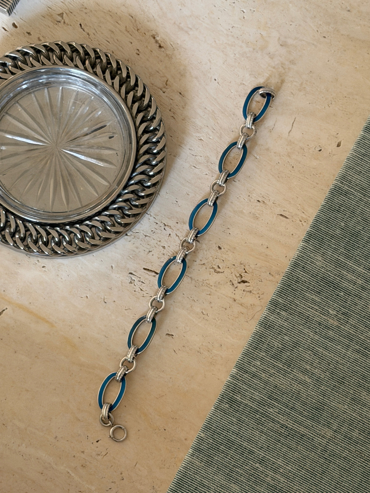 Flat lay view of the blue enamel bracelet showing the fluid link chain