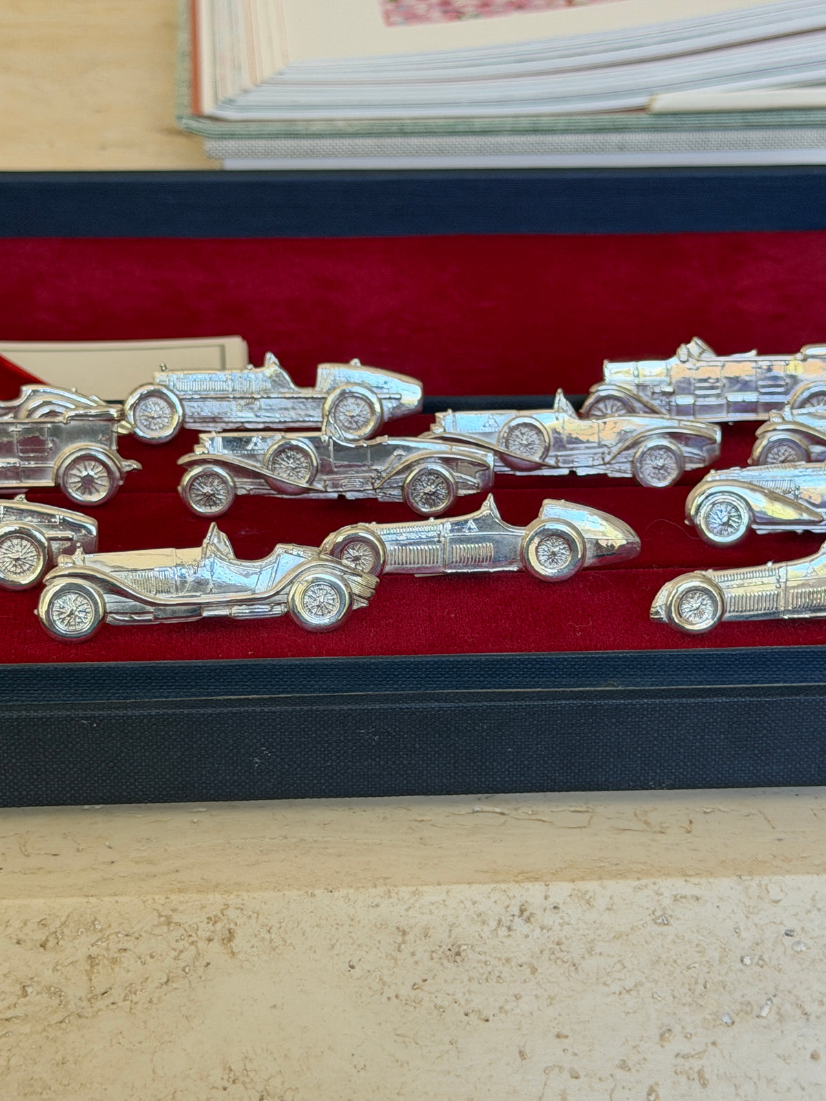 Closer view of several place card holders laid diagonally across the red velvet tray