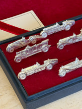 Close angled view of several cars including a flatbed-style holder among the sports car shapes