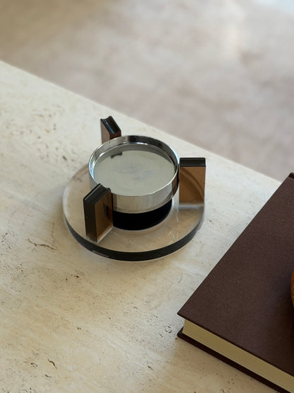 Angled overhead view of the floating ashtray highlighting the grooved tops of the amber uprights that serve as cigarette rests