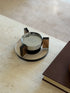 Angled overhead view of the floating ashtray highlighting the grooved tops of the amber uprights that serve as cigarette rests