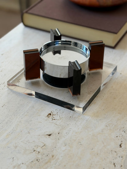 Low angle close view of the square base floating ashtray showing the grooved cigarette rests atop the amber supports and the gap beneath the bowl