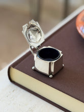 Silver mustard pot with its lid open, revealing the cobalt blue glass liner and hallmarks stamped inside the lid