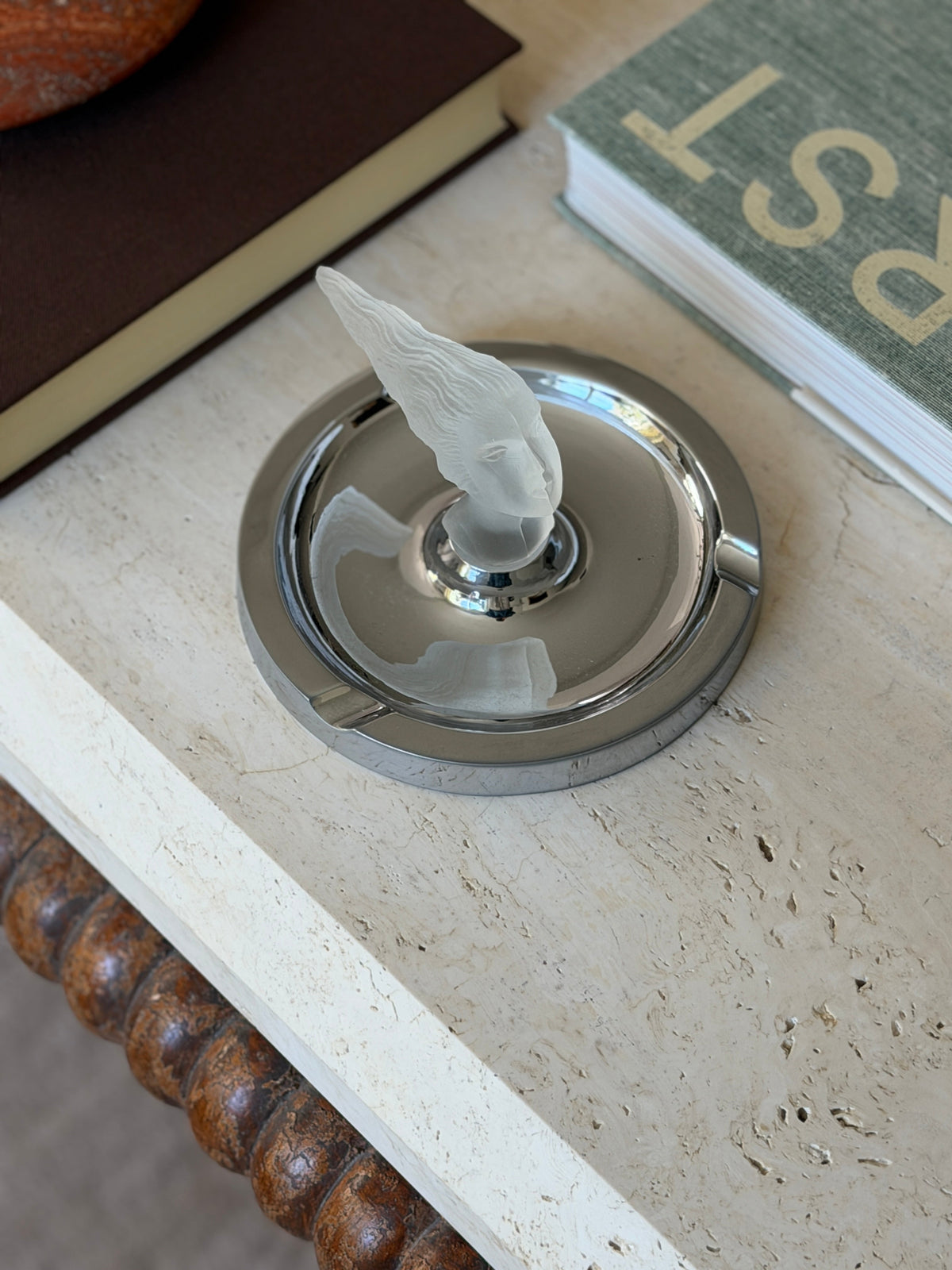 Overhead angled view of the ashtray styled near a marble bowl and stacked books