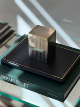Angled perspective view of tall silver plated cedar-lined box displayed on dark green book from Collectors Gene
