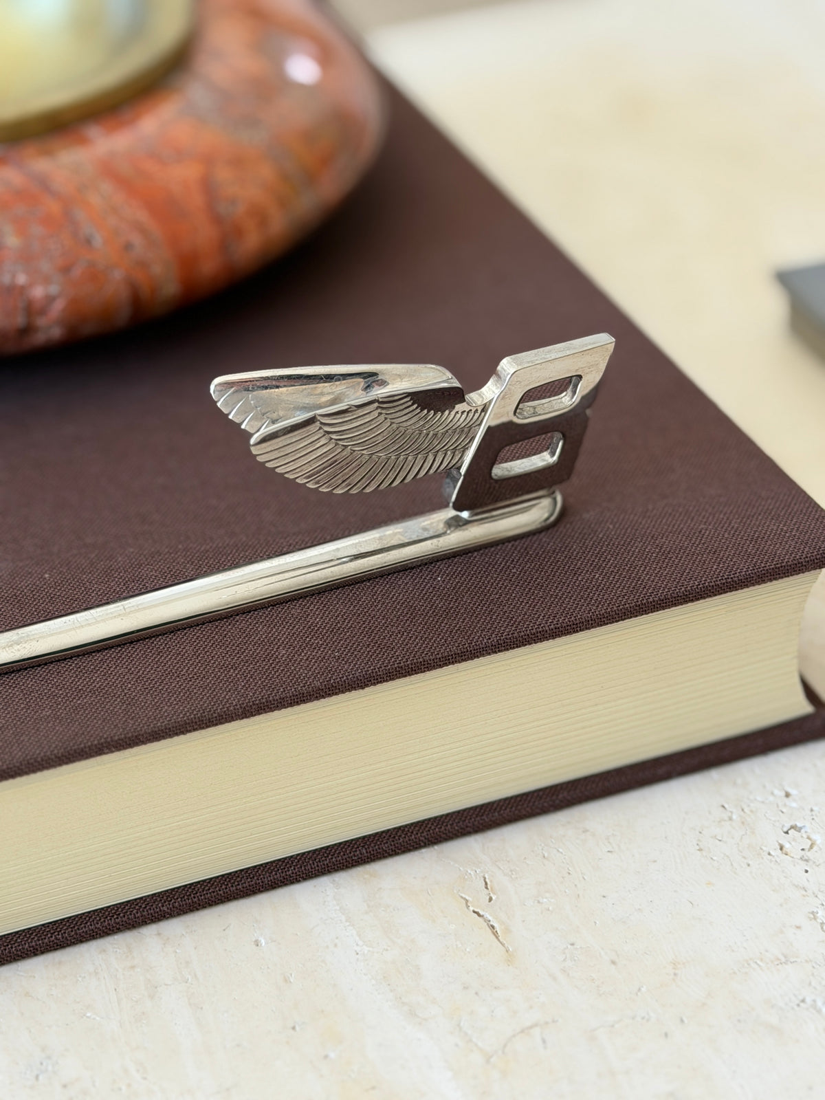 Close up of the Bentley winged B handle, showing the finely detailed feathers and the open B cutout