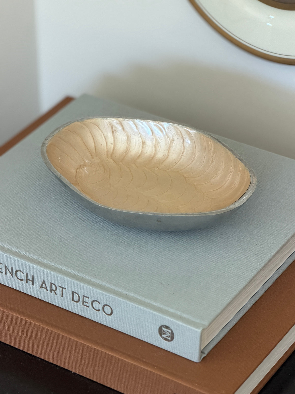 Side perspective view highlighting asymmetrical rim on 1980s Brandani cream aluminum dish at Collectors Gene