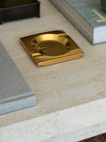 Angled perspective view of Francois de Gross style brass catchall dish displayed on books at Collectors Gene
