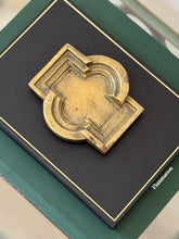 Close-up top-down view of aged bronze architectural geometric tray showing muted gold patina details