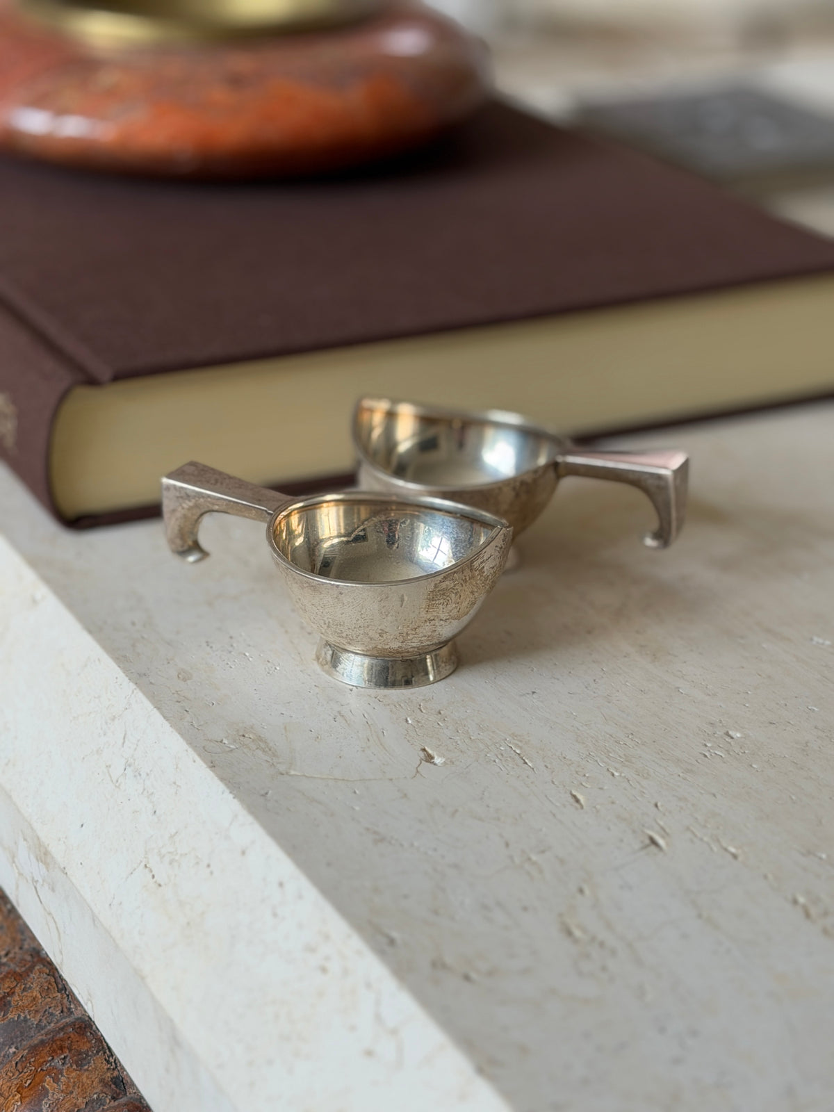 Another angle of the two dishes together, showing the shallow bowl form and squared handle detail