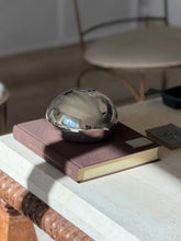 Cartier chestnut box resting on the Superfine Tailoring Black Style book beside a small silver card case on a travertine console