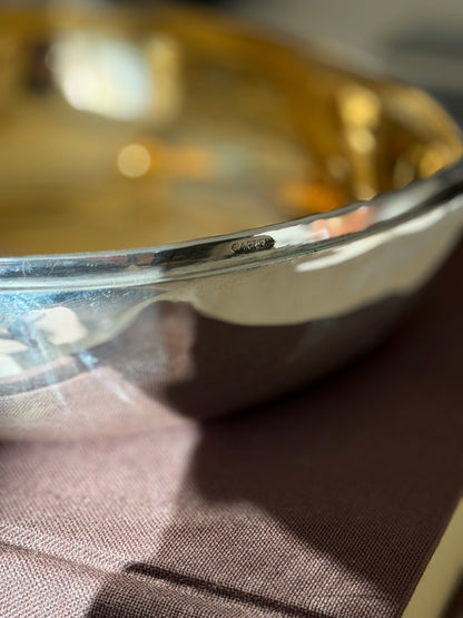 Close up of the CARTIER stamp on the outer rim of the sterling silver chestnut box, the gilt interior glowing behind