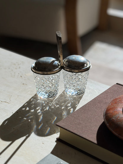 Backlit Cartier jam pot with sun shining through the hobnail cut crystal, the worn patina visible on the domed sterling lids