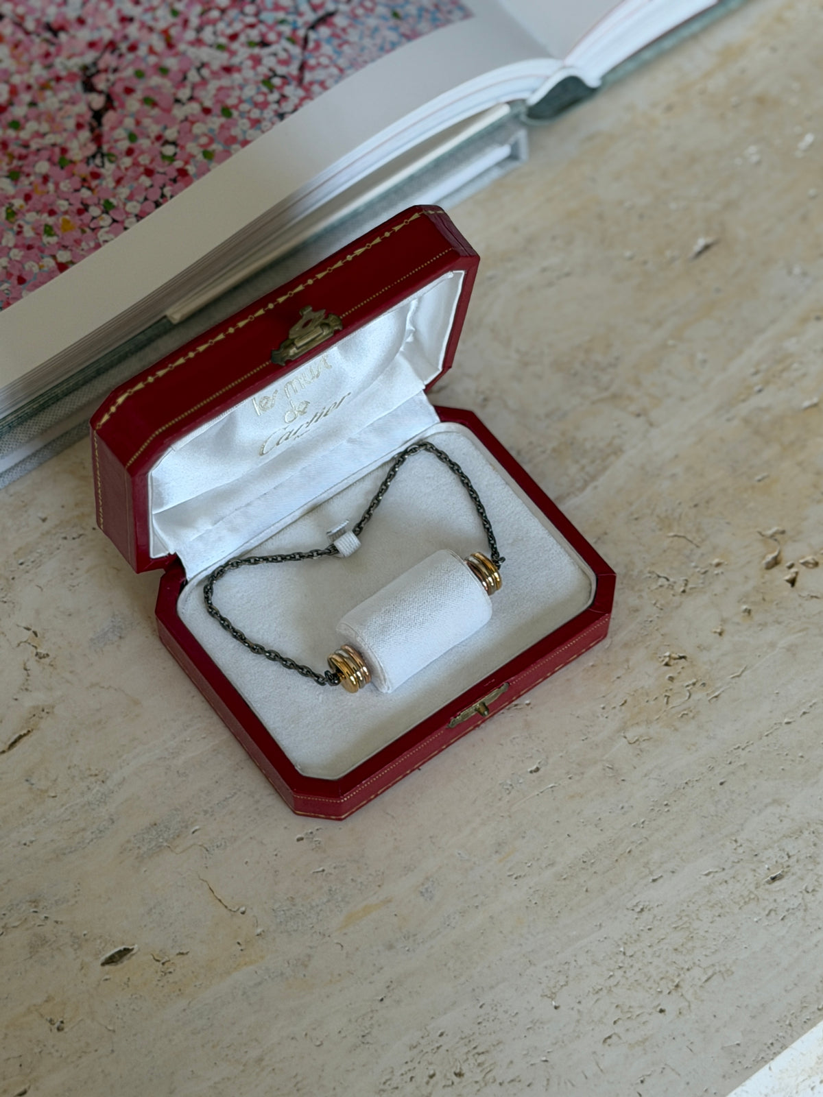 Open box revealing the Les Must de Cartier lining and the gilt cork saver&