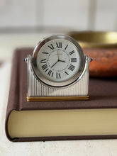 Front view of the Cartier desk clock showing twin sapphire cabochons on either side of the dial and the Swiss Made marking below the numerals