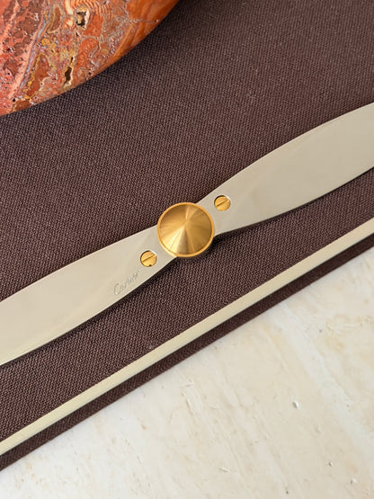 Close up of the propeller hub showing the brushed gold cone, two gold slotted screws, and the Cartier signature engraved on the polished blade