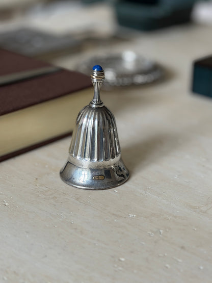 Fluted silver Cartier bell with a lapis lazuli cabochon finial, the Cartier signature visible on the flared base
