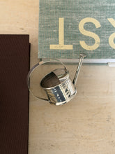 Top-down view of the Cartier vermouth dropper resting on a stack of books