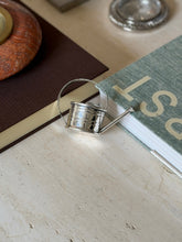 High angle view of the Cartier vermouth dropper on a painted table surface with a glass ashtray and marble dish nearby