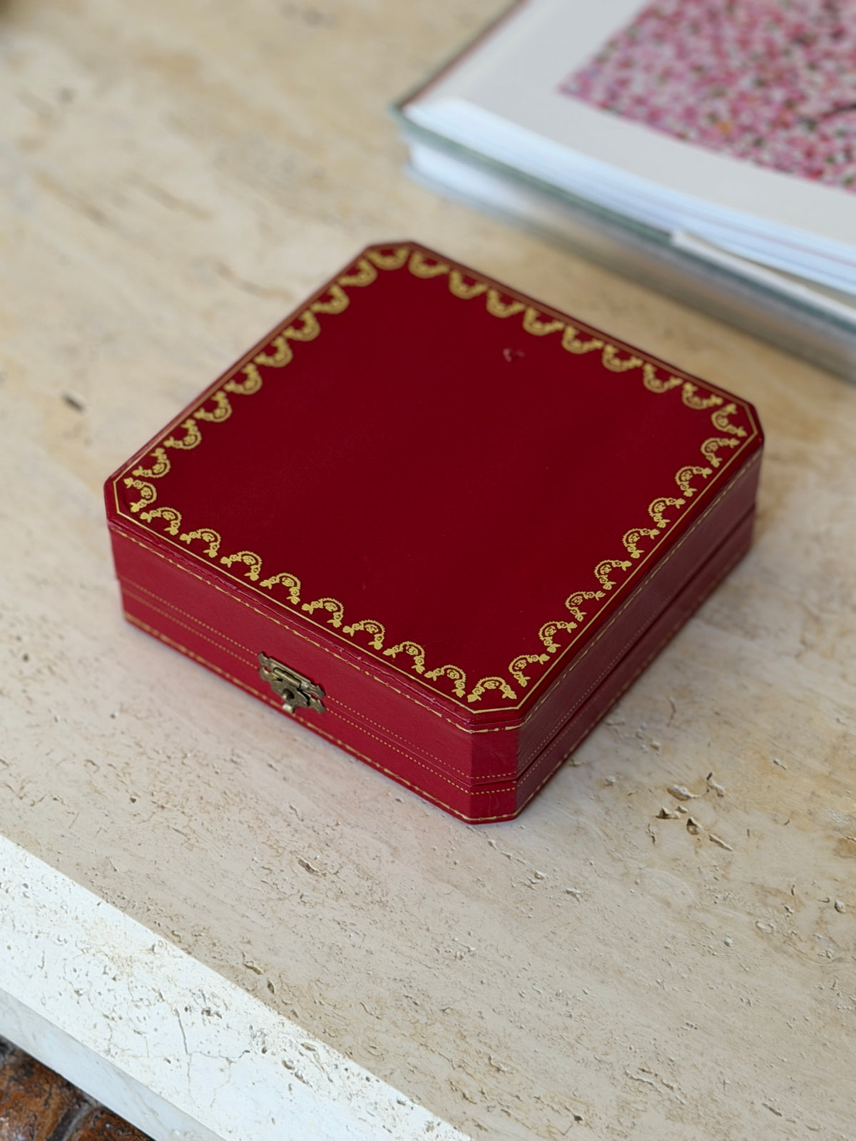 Closed Cartier presentation box shown from a slightly different angle, highlighting the gold trim along the lid&