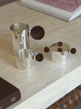 Another angle of the separated Gigogne coffee service pieces on a stone surface, showing the sugar bowl&