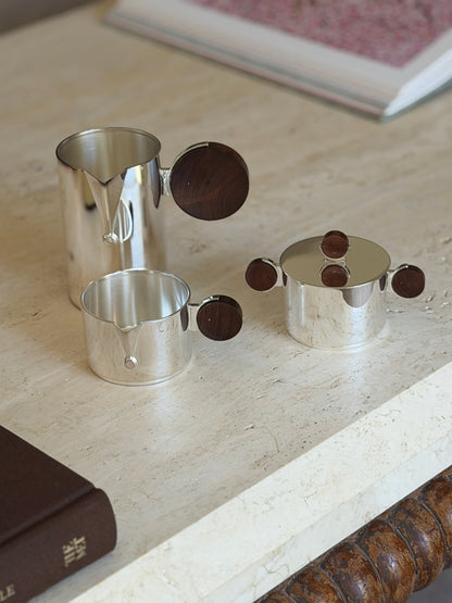 Another angle of the separated Gigogne coffee service pieces on a stone surface, showing the sugar bowl&