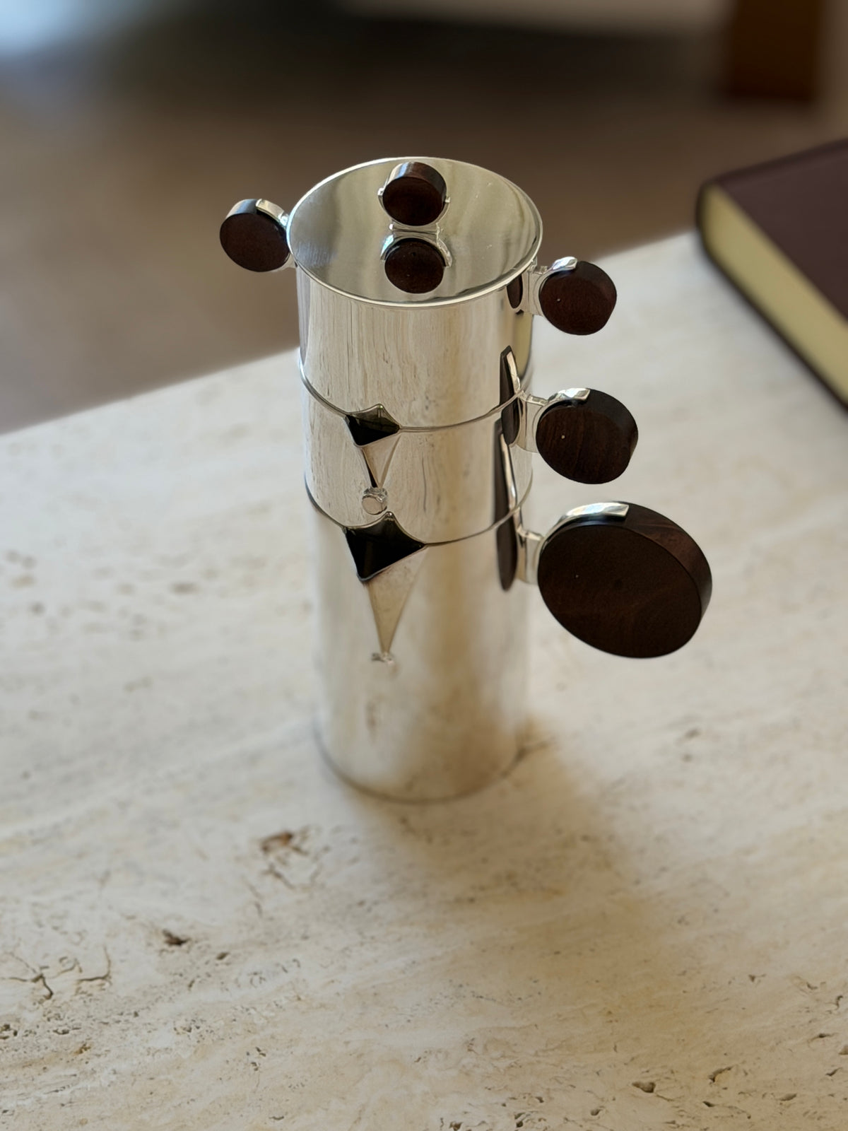 Nested Gigogne coffee service stack on a stone surface beside a leather-bound book