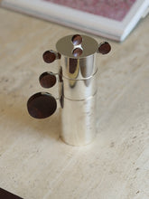 Nested Gigogne coffee service stack against a blurred pink art print in the background
