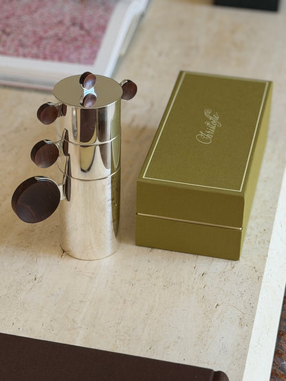 Nested Gigogne coffee service stack beside its original olive green Christofle presentation box