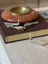 Christofle Gallia peacock and dove knife rests styled on a leather book, four pieces visible