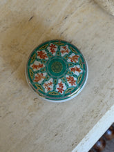 Top-down view showing green and orange ginkgo leaf pattern with gold trim on Christofle porcelain box