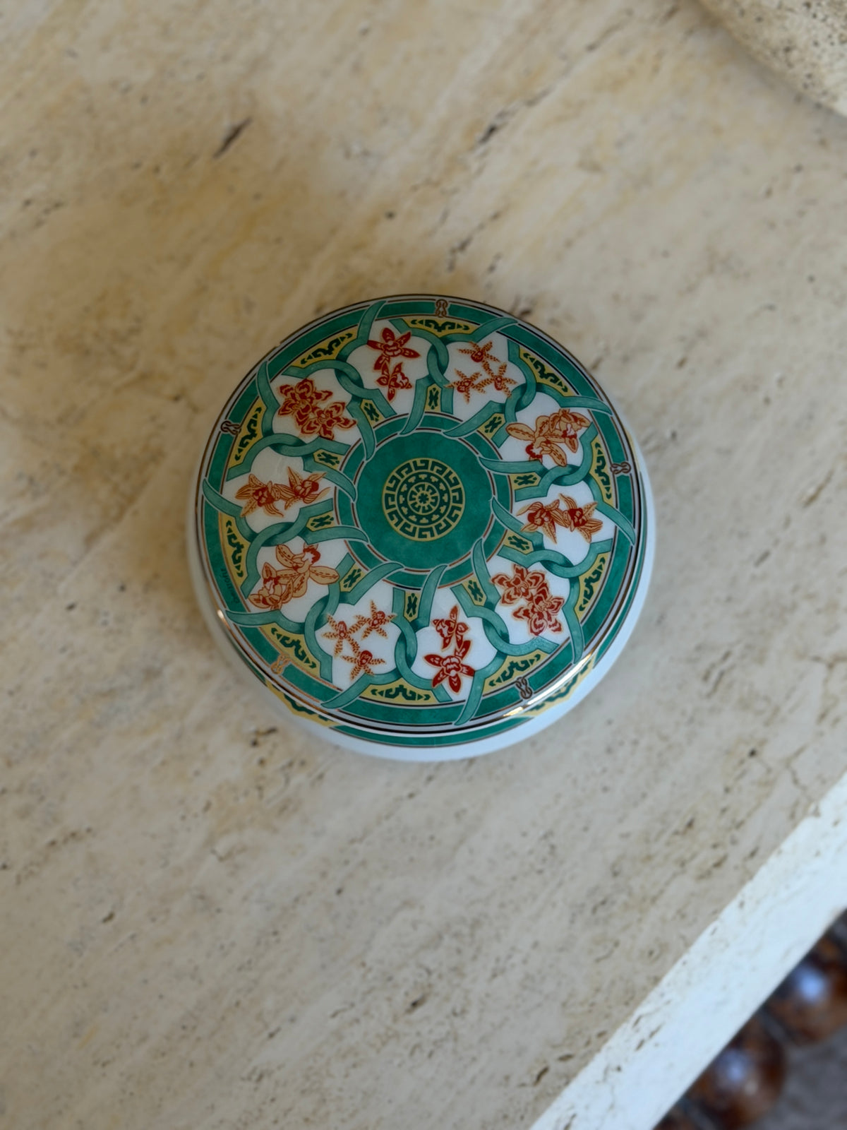 Top-down view showing green and orange ginkgo leaf pattern with gold trim on Christofle porcelain box