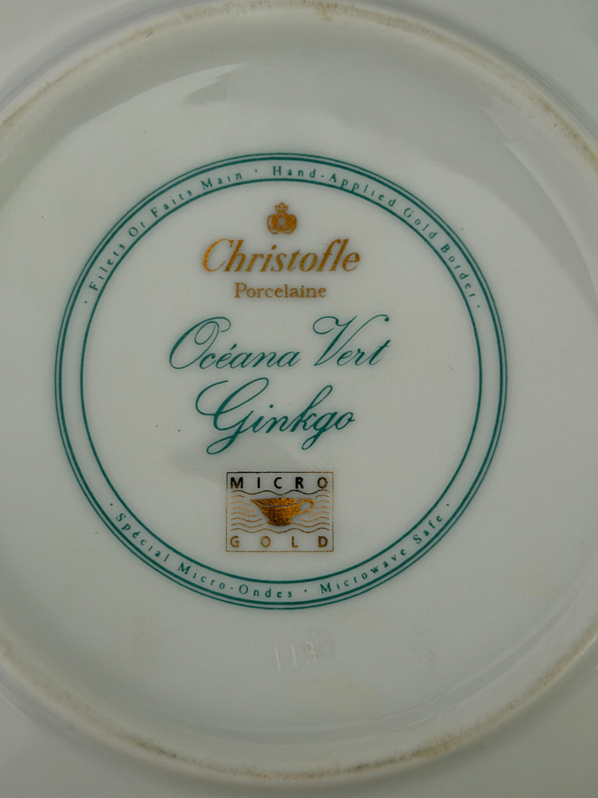 Close-up view of green Christofle Paris Oceana Vert Ginkgo maker mark stamp on underside of porcelain box