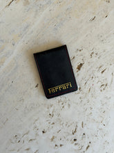 Full view of the black leather Ferrari pouch with gold-stamped branding
