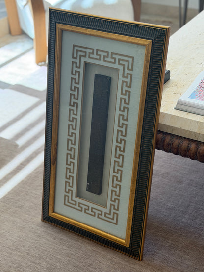 Framed Chinese Lu Ban ruler with engraved characters, set in a shadowbox with a cream mat and gold key fret border inside a fluted dark and gilt frame