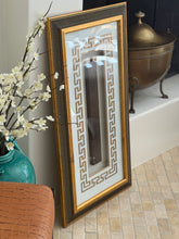 Side angle of the framed Lu Ban ruler showing reflections on the glass front, a brass coal scuttle on the hearth behind