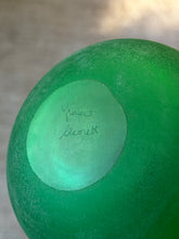 Base of the green vanity bottle showing the engraved Franco Moretti signature on the smooth polished center