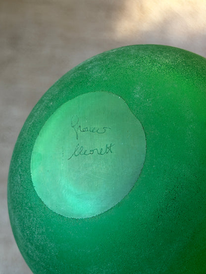 Base of the green vanity bottle showing the engraved Franco Moretti signature on the smooth polished center