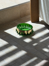 Collectors Gene vintage emerald green glass vide poche with hammered brass collar in natural sunlight on stone floor