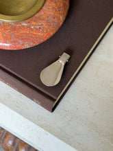 Fully extended Gucci folding travel shoehorn showing the polished metal blade