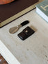 Overhead view of the folded Gucci shoehorn and its brown monogram leather case